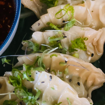 Edamame dumpling platter with chili garlic sauce, vegan